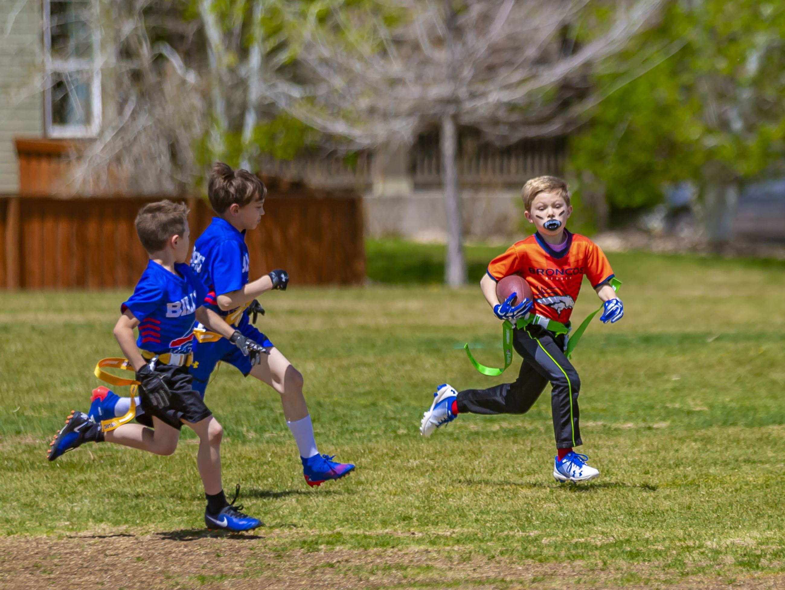 Photo of a young boy running with a football