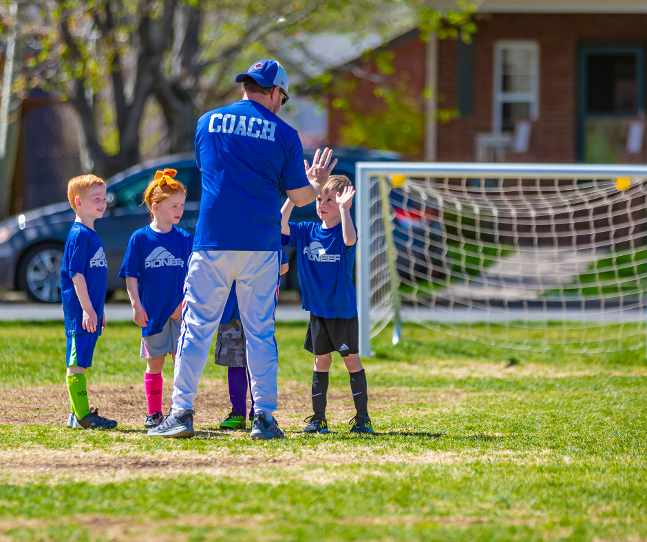 Photo of a soccer coach giving a high five to one of his soccer players