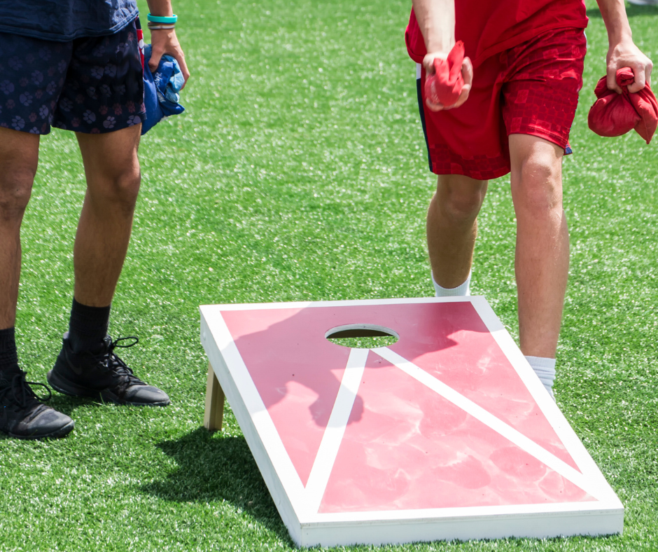 Photo of two people playing a game of cornhole